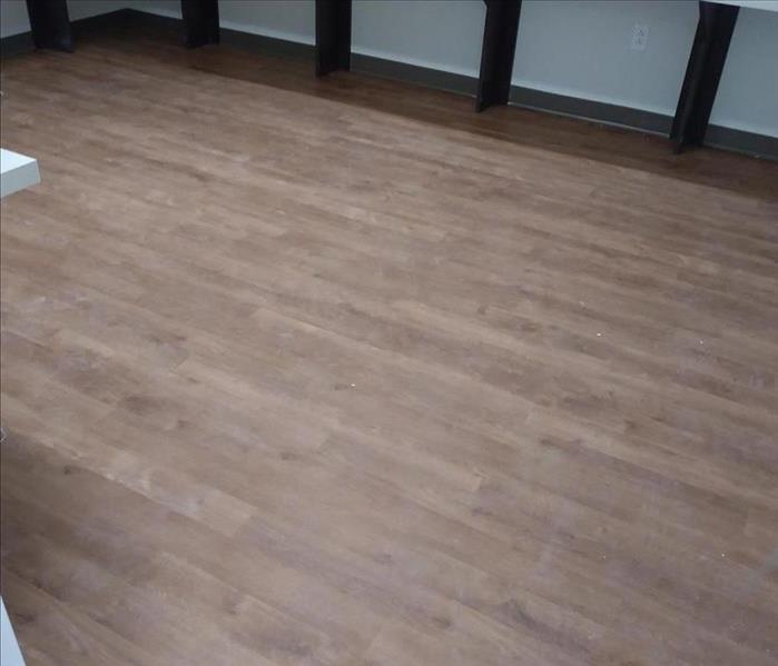 image of commercial hardwood floor looking dirty and dark due to winter months foot traffic