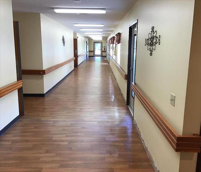 image of nursing home hallway with visible sitting water on the right side of the hallway 