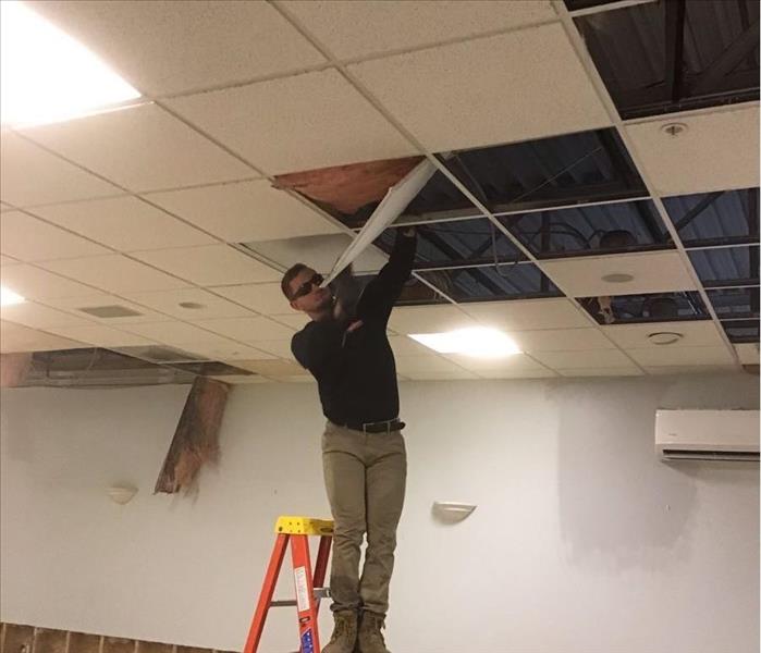SERVPRO team member works in a commercial office's ceiling.