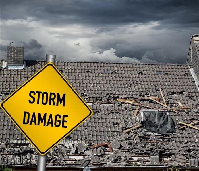 picture is of a commercial roof with a yellow sign titled storm damage
