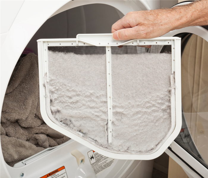Picture shows a close-up of a lint tray filled with dryer lint. 